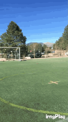 a man in a white shirt and shorts is running on a soccer field with imgplay written on the bottom