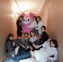 a group of girls posing with a stuffed animal