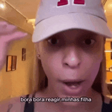 a woman wearing a hat says bora bora reagir minhas filha in a video .