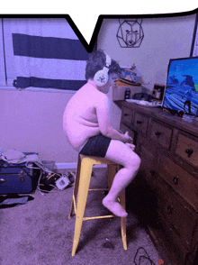 a man wearing headphones sits on a yellow stool