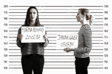 two women standing next to each other holding signs that say marina bommas and janina gaer