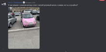 a pink car is parked in a parking lot next to a white car