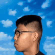 a man wearing glasses and earrings is looking at the sky