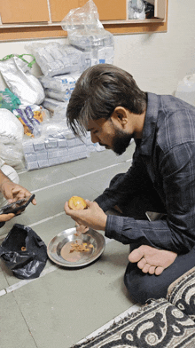 a man kneeling down with a plate of food