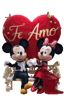 mickey mouse and minnie mouse are sitting on a bench in front of a red heart that says te amo