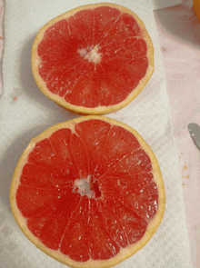 two slices of grapefruit sit on a paper towel