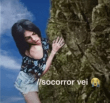 a woman is climbing up a rock with the words socorro vei on the bottom .