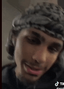 a close up of a man wearing a headband and a bandana .