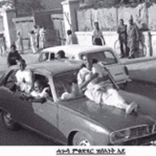 a group of people are sitting in a car on a street .