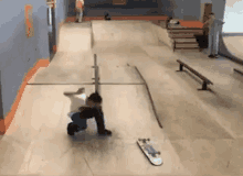 a young boy is riding a skateboard down a ramp in a skate park .