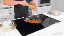 a man is stirring a sauce in a wok on a stove with the words made in animatica visible in the corner