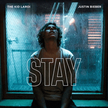 justin bieber 's album cover for stay features a man sitting on a window sill