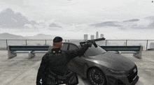 a man holding a gun in front of a black audi