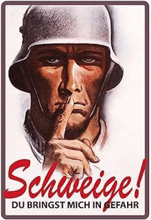 a soldier is holding his finger to his mouth .