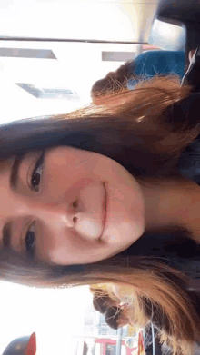 a close up of a woman 's face with a smile on her face and a blurry background .