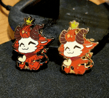 a pair of red and white pins with horns on them