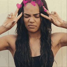 a woman with long hair and pink hearts on her head is making a face .