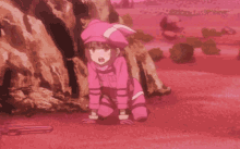 a pink cartoon character is laying on the ground in a desert