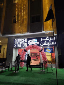 the outside of a burger station with balloons in front of it