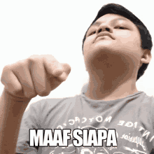 a man wearing a shirt that says maaf siapa is pointing at the camera