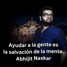 a man in a blue shirt stands in front of a building with the words ayudar a la gente es la salvacion de la mente