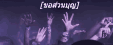a crowd of people are raising their hands in the air .