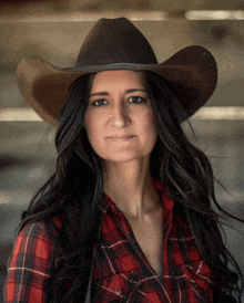 a woman in a plaid shirt and cowboy hat