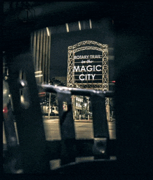 a sign for the rotary trail in the magic city is seen through a fence