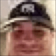 a blurry picture of a man wearing a hat with a letter r on it .