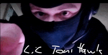 a man wearing a black mask with the name l.c. toni hawk written on the bottom