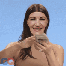 a woman is smiling while holding a pile of money