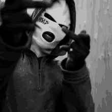 a person wearing a ski mask with the word hood on it giving the middle finger