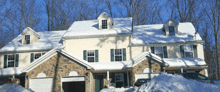 a large house with snow on the roof and a car parked in front of it