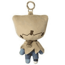 a stuffed animal with a scarecrow head is hanging from a key chain .