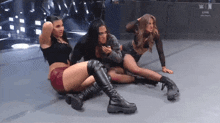 a group of women are sitting on the floor in front of a sign that says n on it