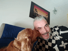 a man with a beard and a dog licking his face