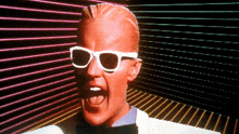 a man wearing white sunglasses is screaming in front of a colorful background