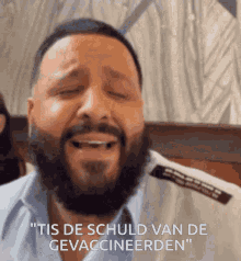 a man with a beard is crying and saying " tis de schuld van de gevaccineerden " in a foreign language