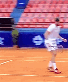 a man is playing tennis on a court in front of a sign that says ' g ' on it