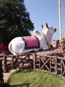 a large statue of a cow with a red and blue saddle