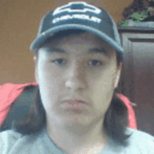 a woman is wearing a chevrolet hat and a gray shirt