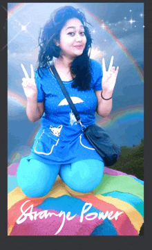 a woman in a blue shirt is kneeling on a colorful blanket with the words strange power written on the bottom