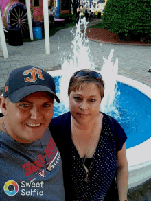 a man wearing a hat with the number 31 on it poses with a woman