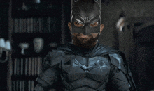 a man with a beard wears a batman costume