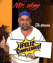 a man in a blue hat holds a sign that says feliz cumpleanos