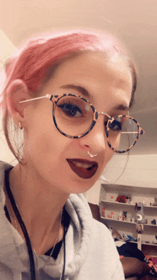 a woman wearing glasses and a nose ring