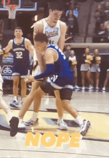 a basketball player with the number 32 on his jersey is being fouled by another player