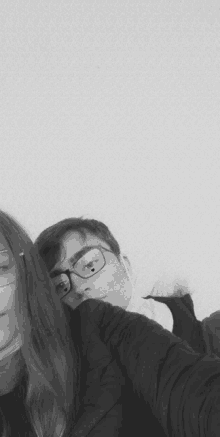 a black and white photo of a boy and a girl with glasses