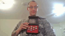 a man wearing glasses is holding a box with buttons in it