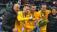 a group of soccer players are posing for a picture with a trophy that says ' inter ' on it